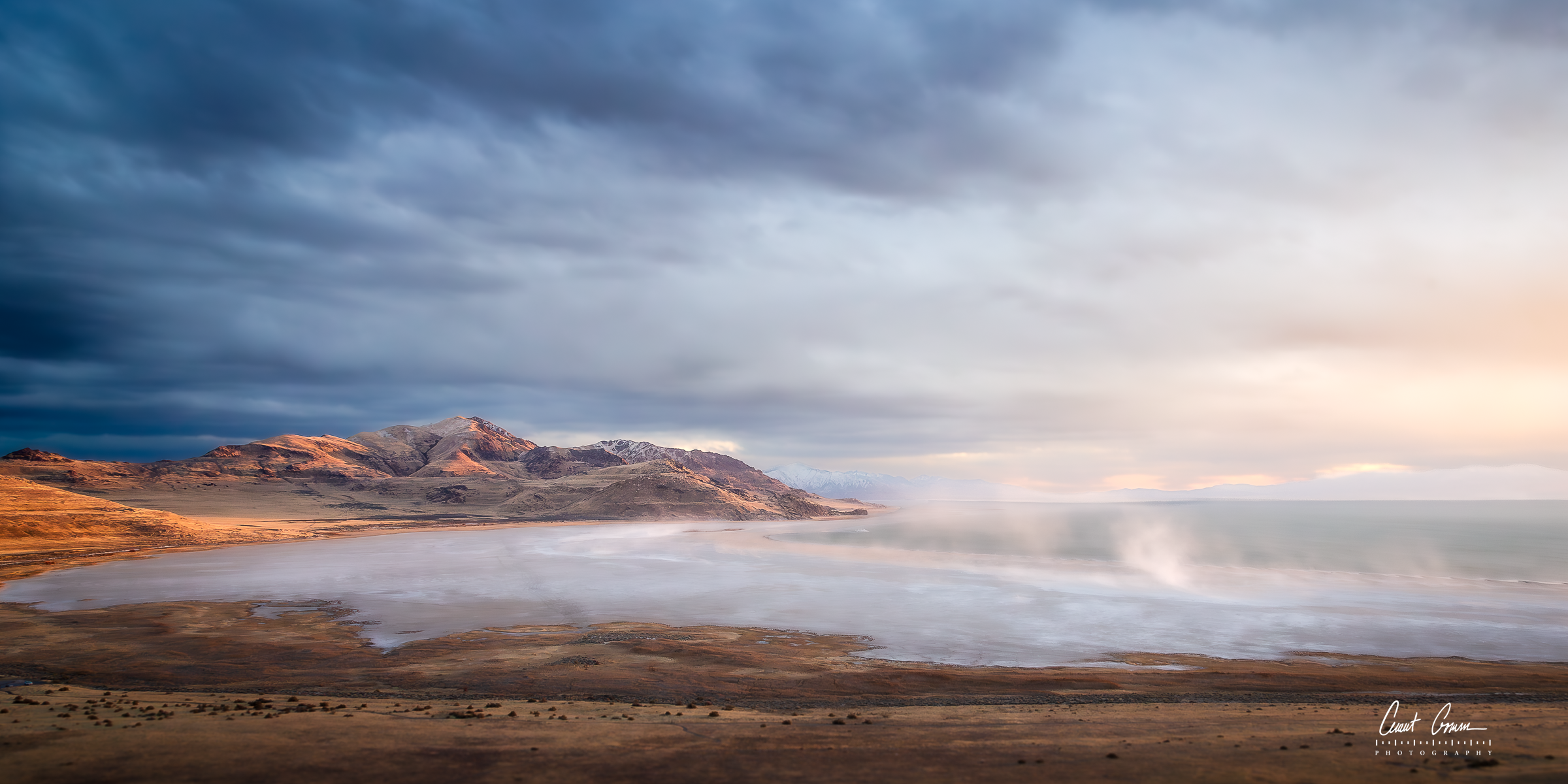 White Rock Bay on Antelope Island Utah with low mist over the Great Salt Lake and layered clouds above the ridgeline